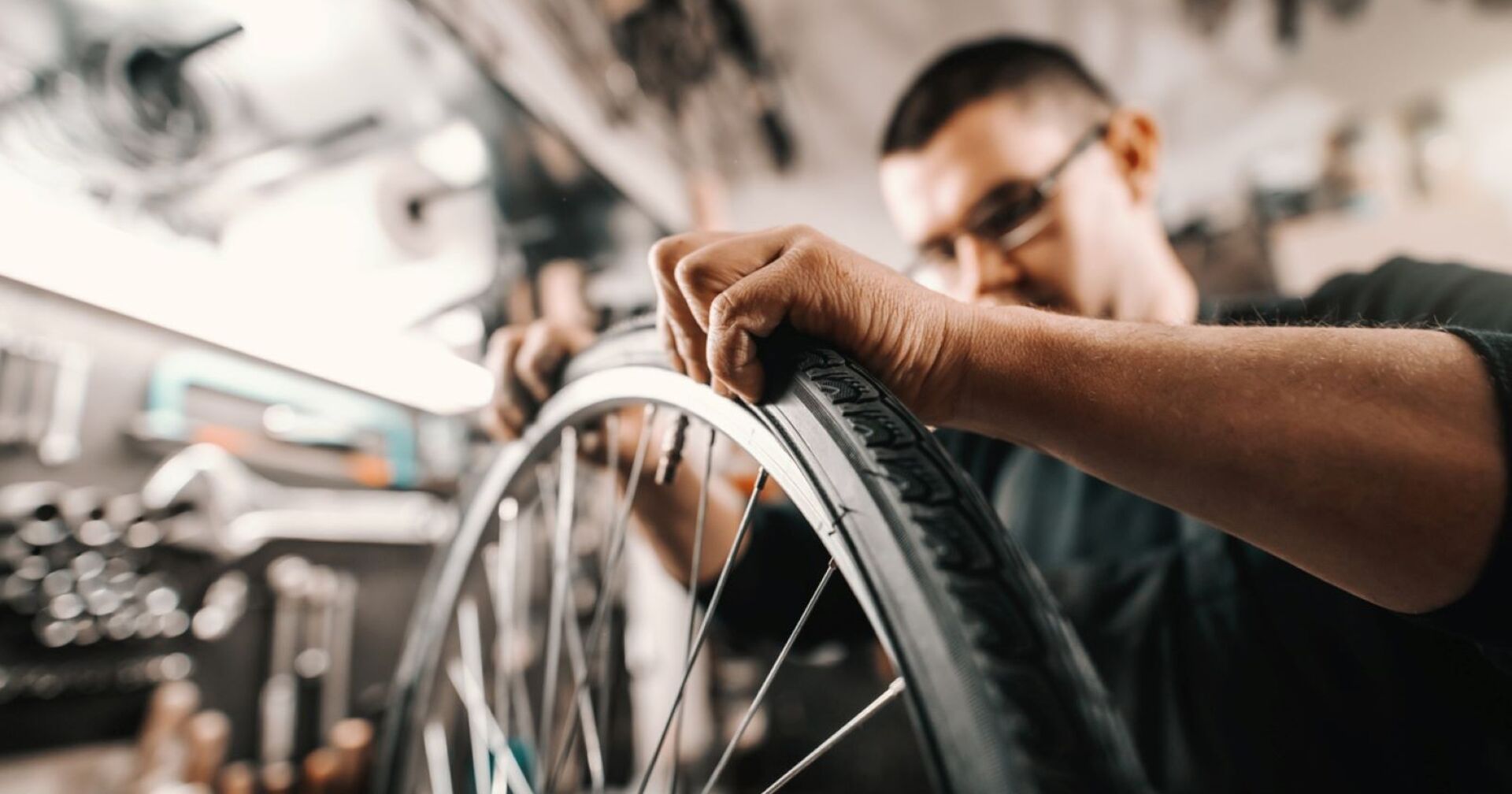 Ein junger Mann repariert ein kaputtes Fahrrad.