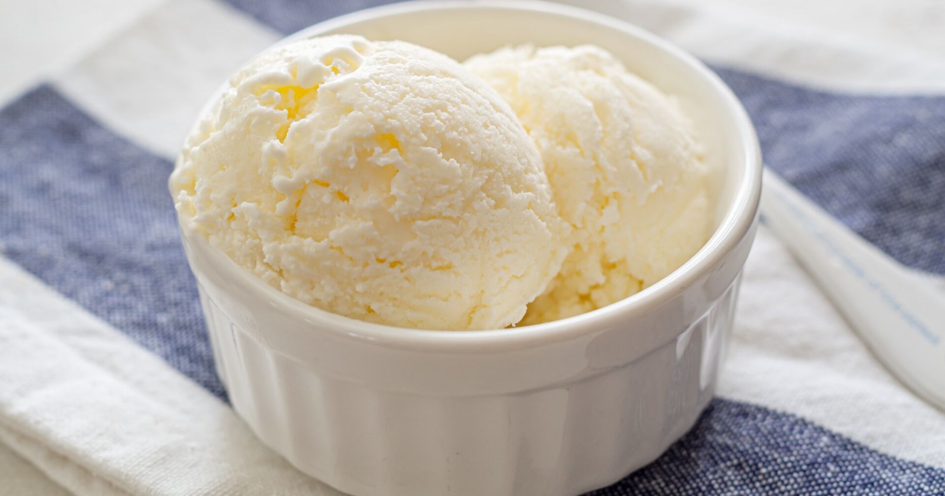 Zwei Vanilleeiskugeln in einer Porzellanschale.