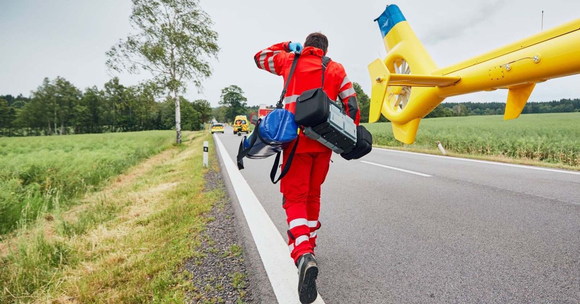 Ein Sanitäter eilt von einem Hubschrauber zu einem Einsatzort.