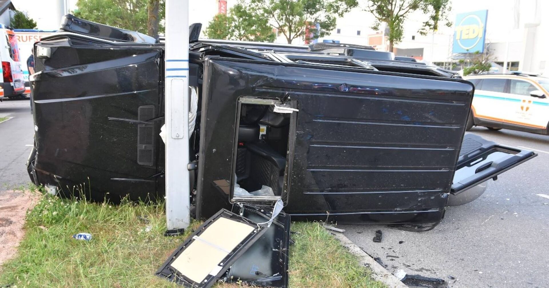 Schwarzer Unfallwagen kracht gegen Lichtmast.
