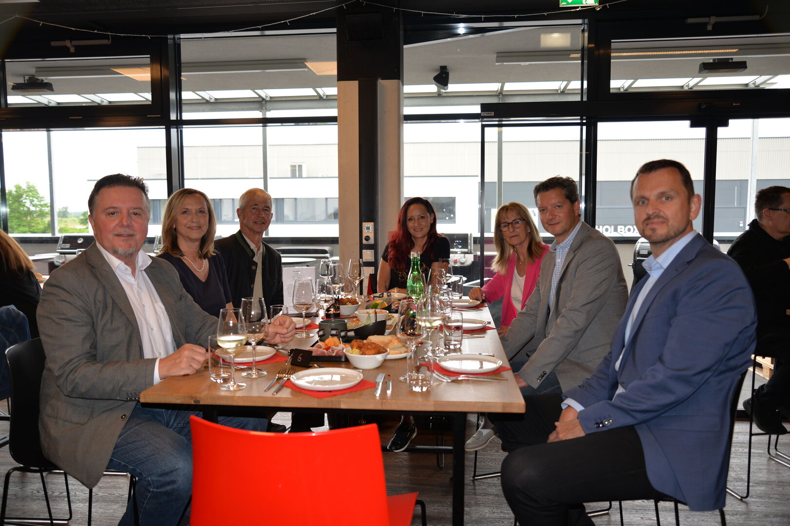 Mehrere Männer und Frauen sitzen an einem Tisch