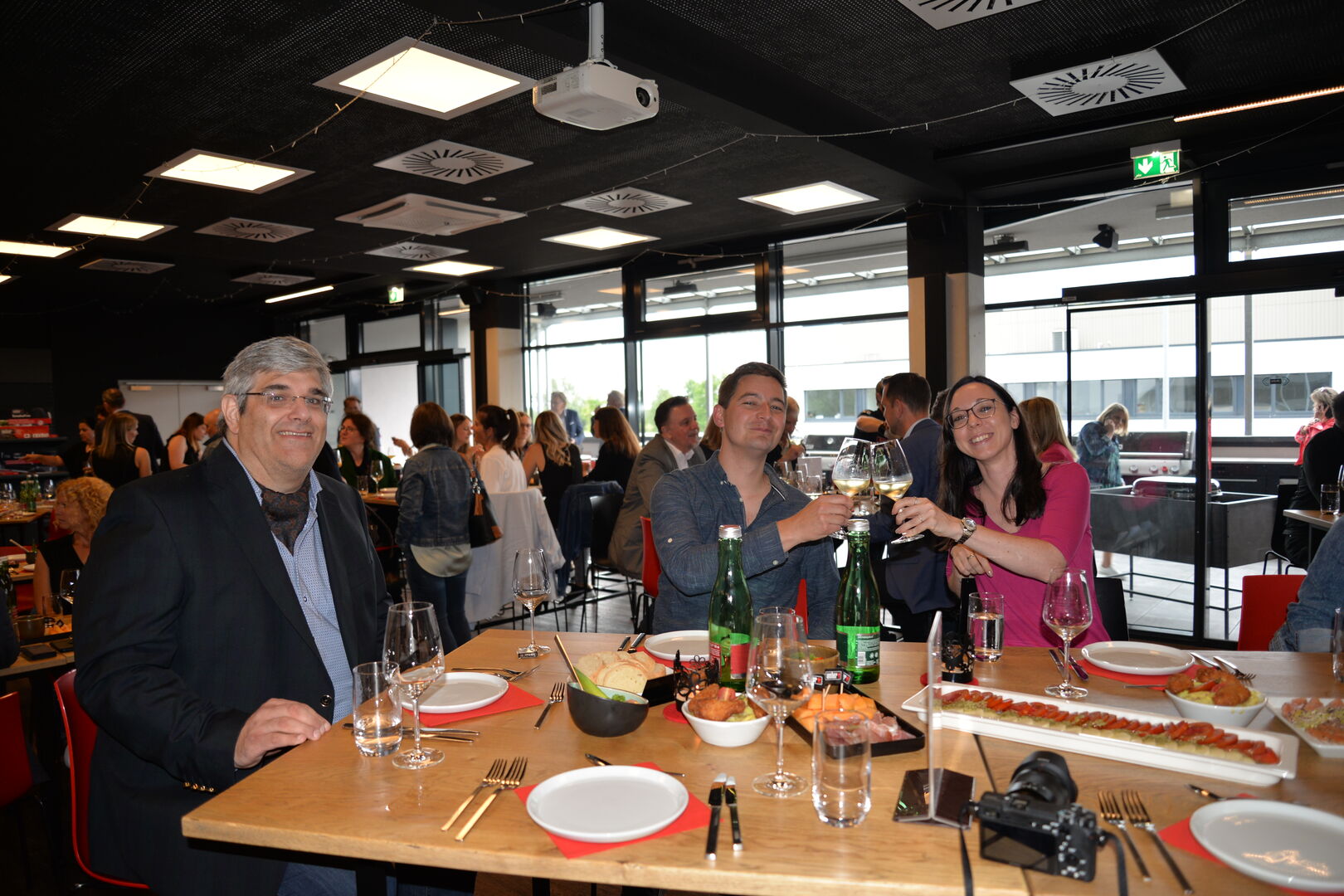 Zwei Männer und eine Frau sitzen an einem Tisch