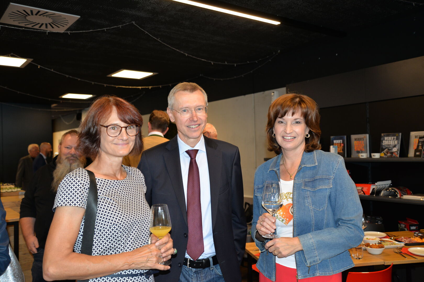 Zwei Frauen und ein Mann blicken in die Kamera