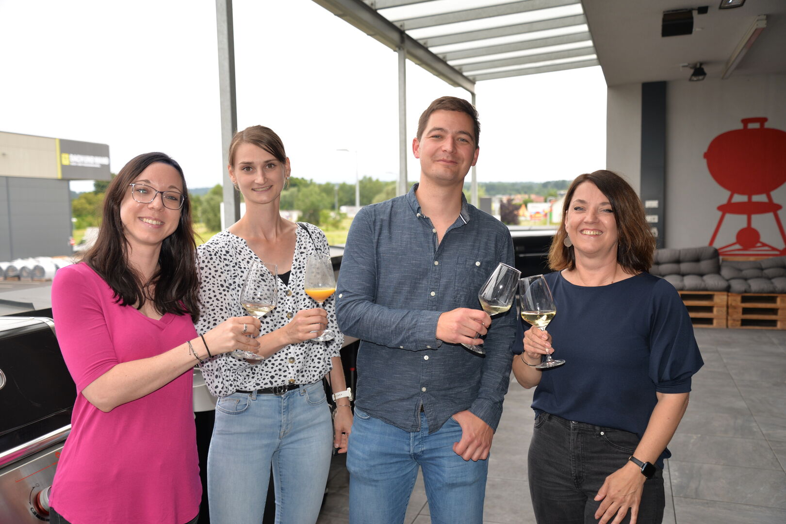 Drei Frauen und ein Mann stehen auf einem Balkon