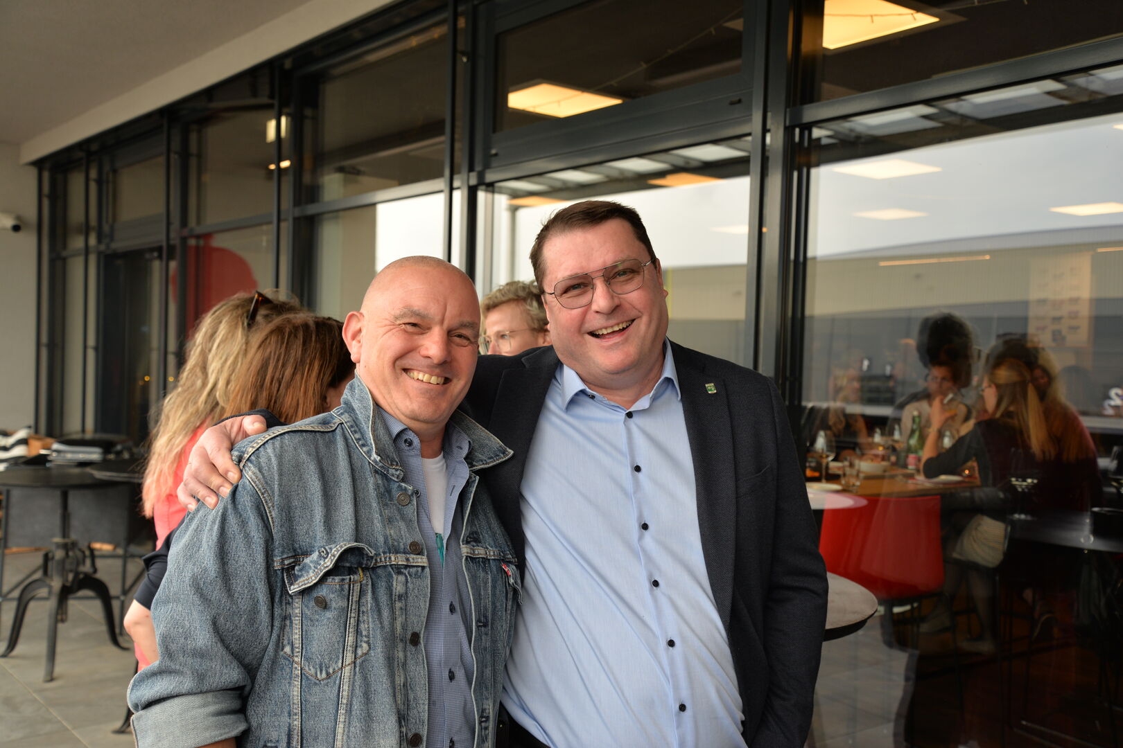 Zwei Männer stehen nebeneinander auf einem Balkon