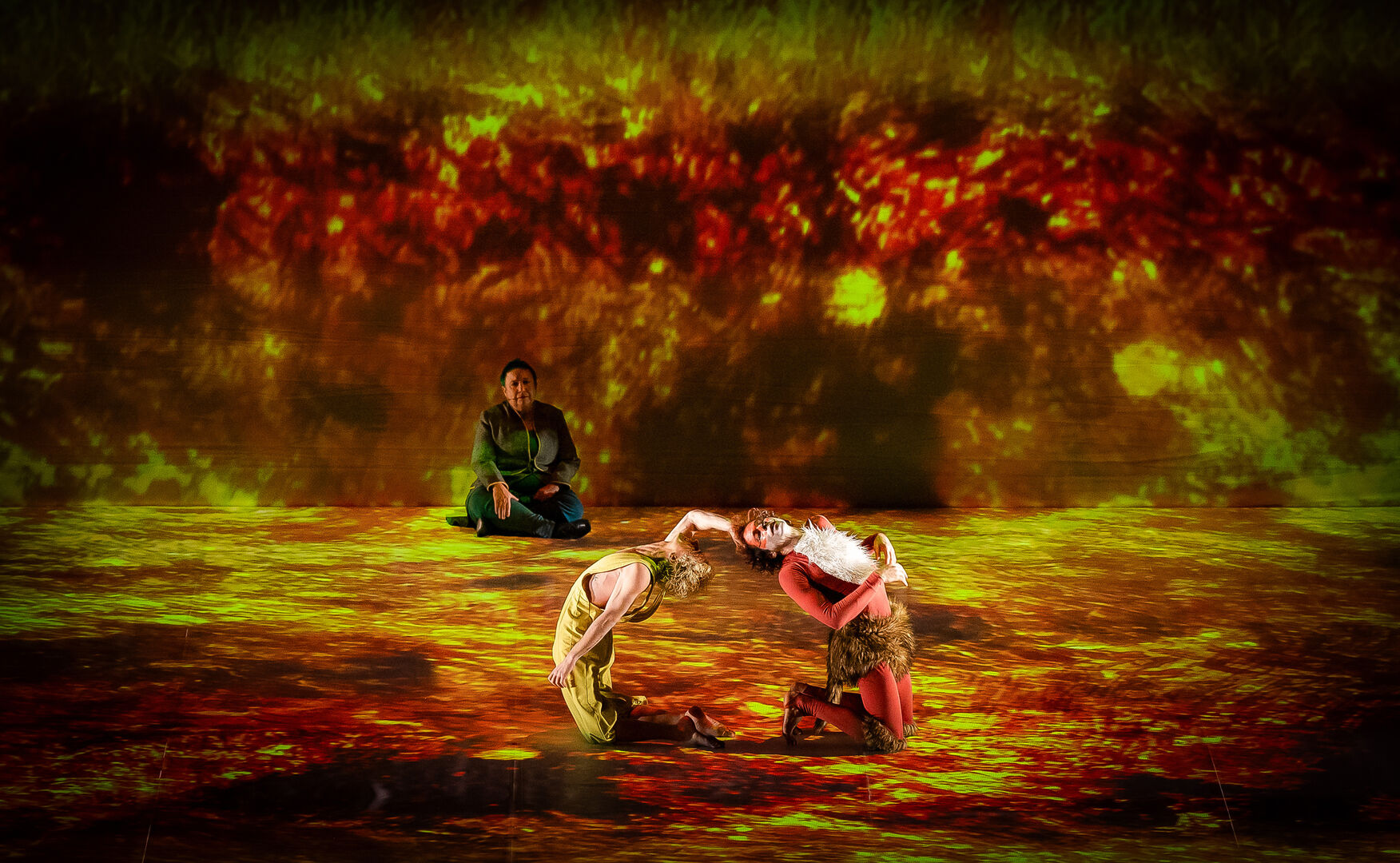 Mehrere Schauspieler sitzen auf einer Bühne