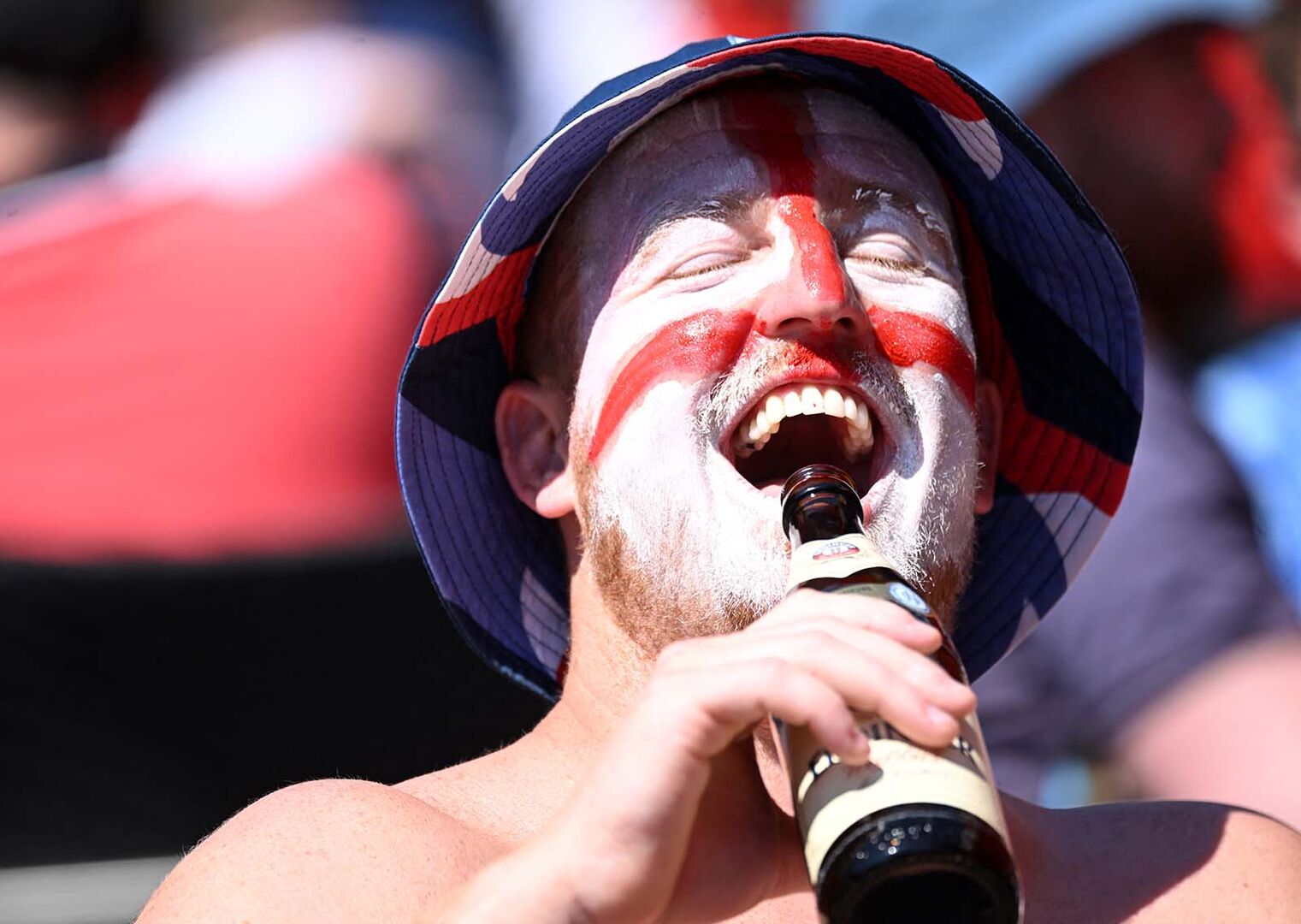 Ein englischer Fußballfan, der eine Flasche Bier trinkt.