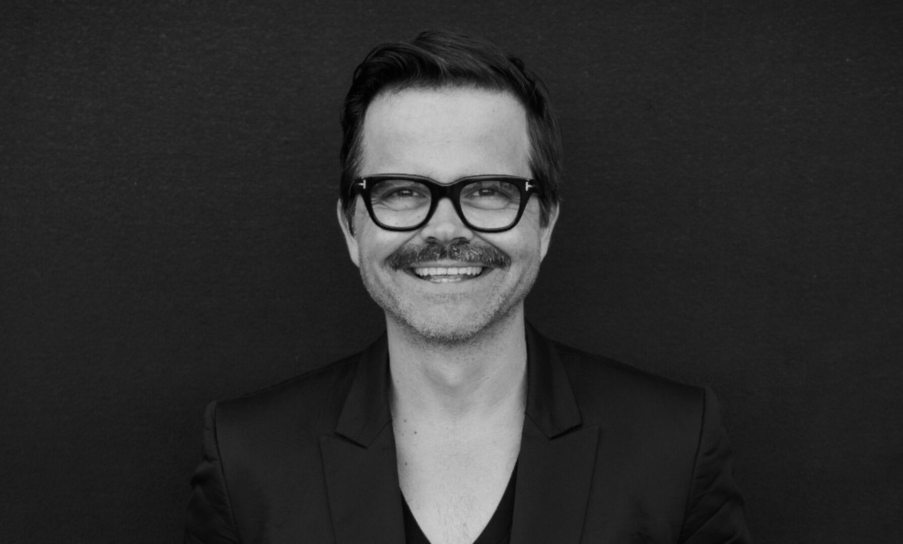 Ein schwarz-weißes Foto von einem Mann mit Brille