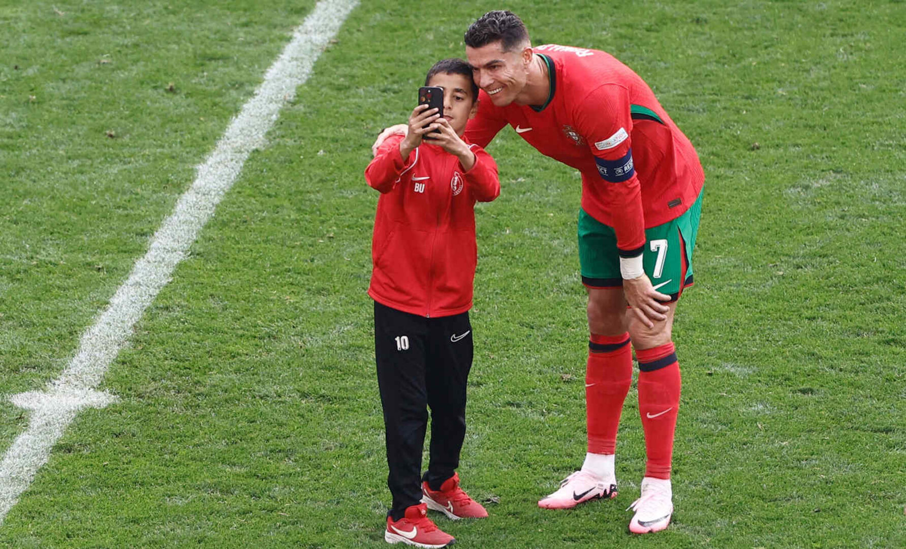 Ein Fußballspieler macht gemeinsam mit einem Fan ein Selfie