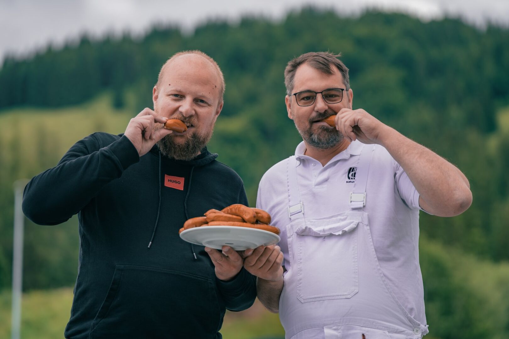Hannes Hönegger und Jürgen Horngacher beißen in ihre Currywurst.