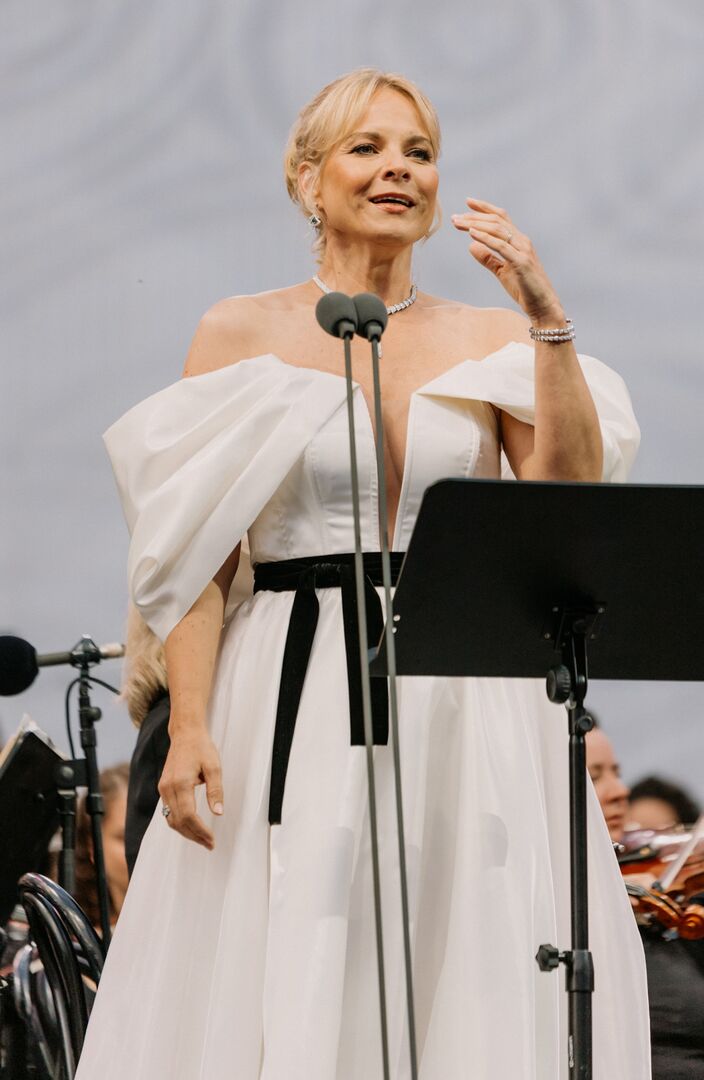 Elina Garanca in einem Galakleid vor einem Mikrophon