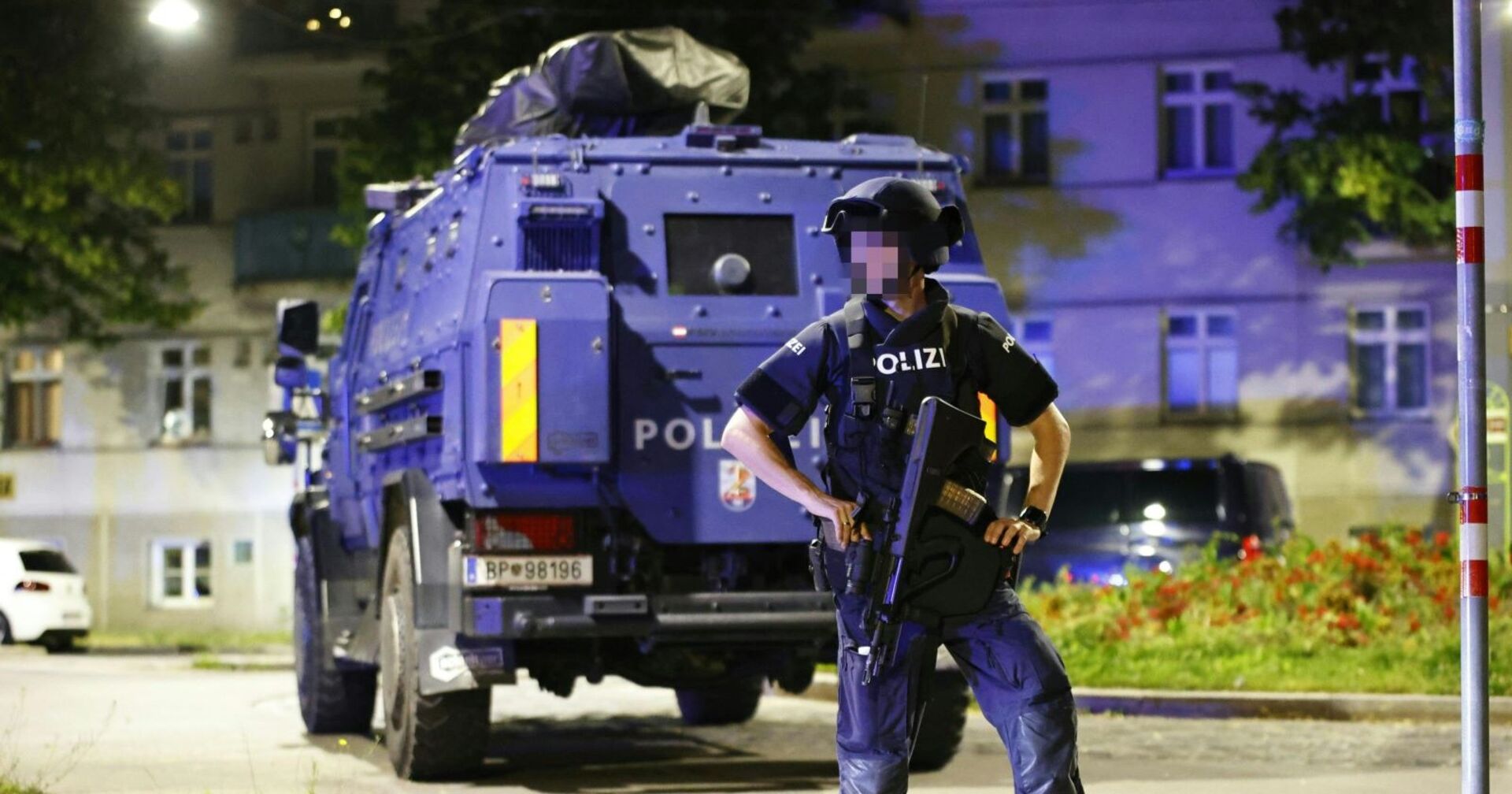 Ein Polizist vor dem Panzerwagen der Wega in der Nacht