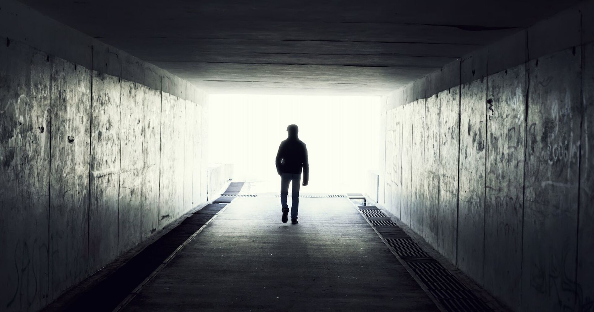 Ein Mann in einem Tunnel von hinten.