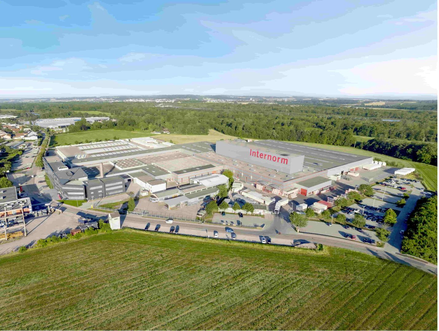 Der Internorm-Standort in Traun aus der Luft. Zu sehen ist die Fabrik, eine Straße und die Felder, die das Werk umgeben.