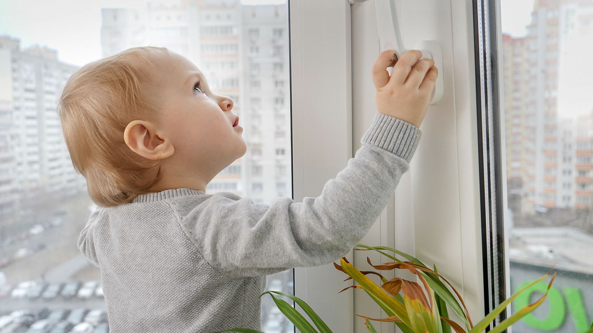 Kind steht am Fenster | Credit: iStock.com/Artfoliophoto