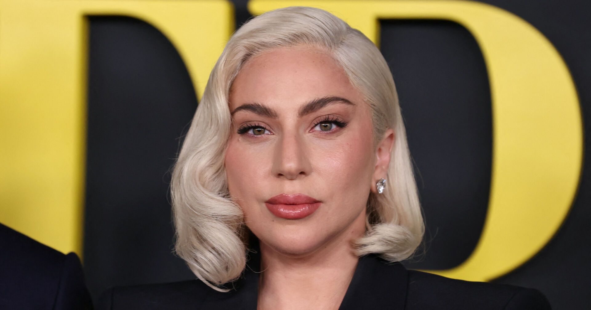Lady Gaga mit gewellten schulterlangen blonden Haaren.