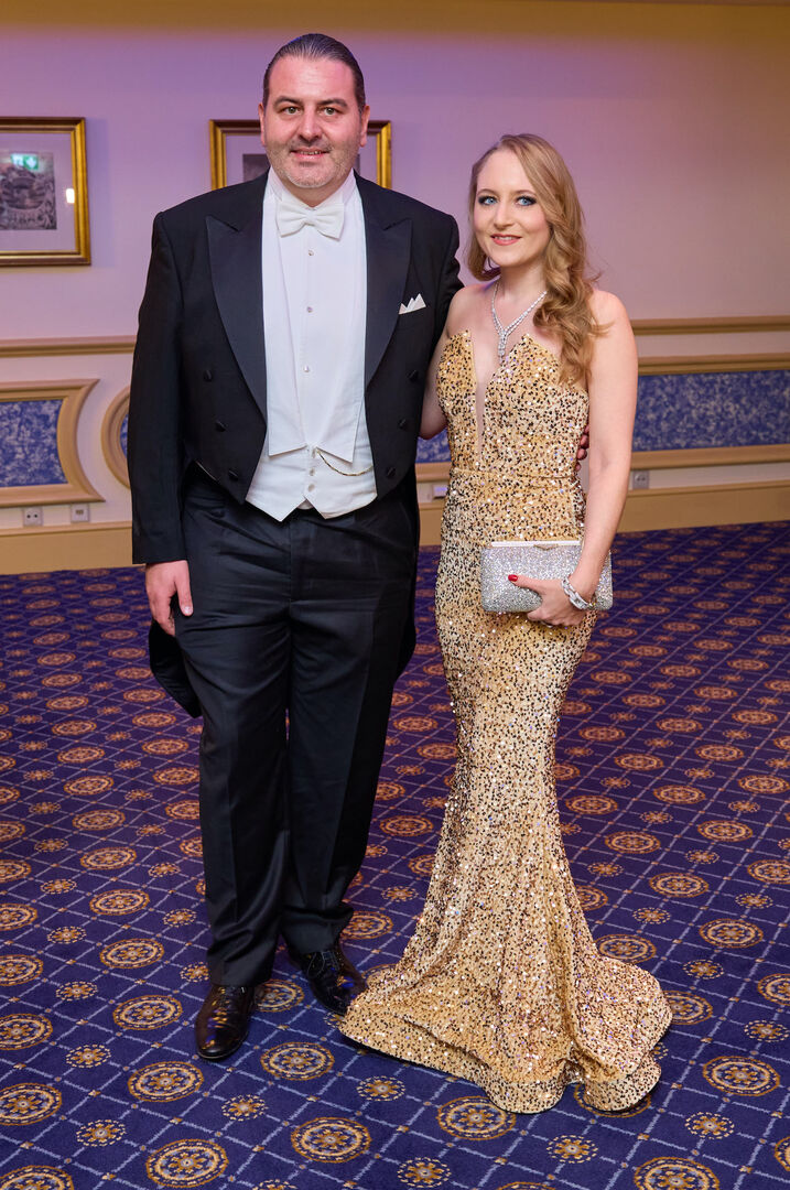 Jacqueline Lugner und Leo Kohlbauer am Wiener Opernball. Sie trägt ein goldenes langes Kleid und Leo einen Anzug.