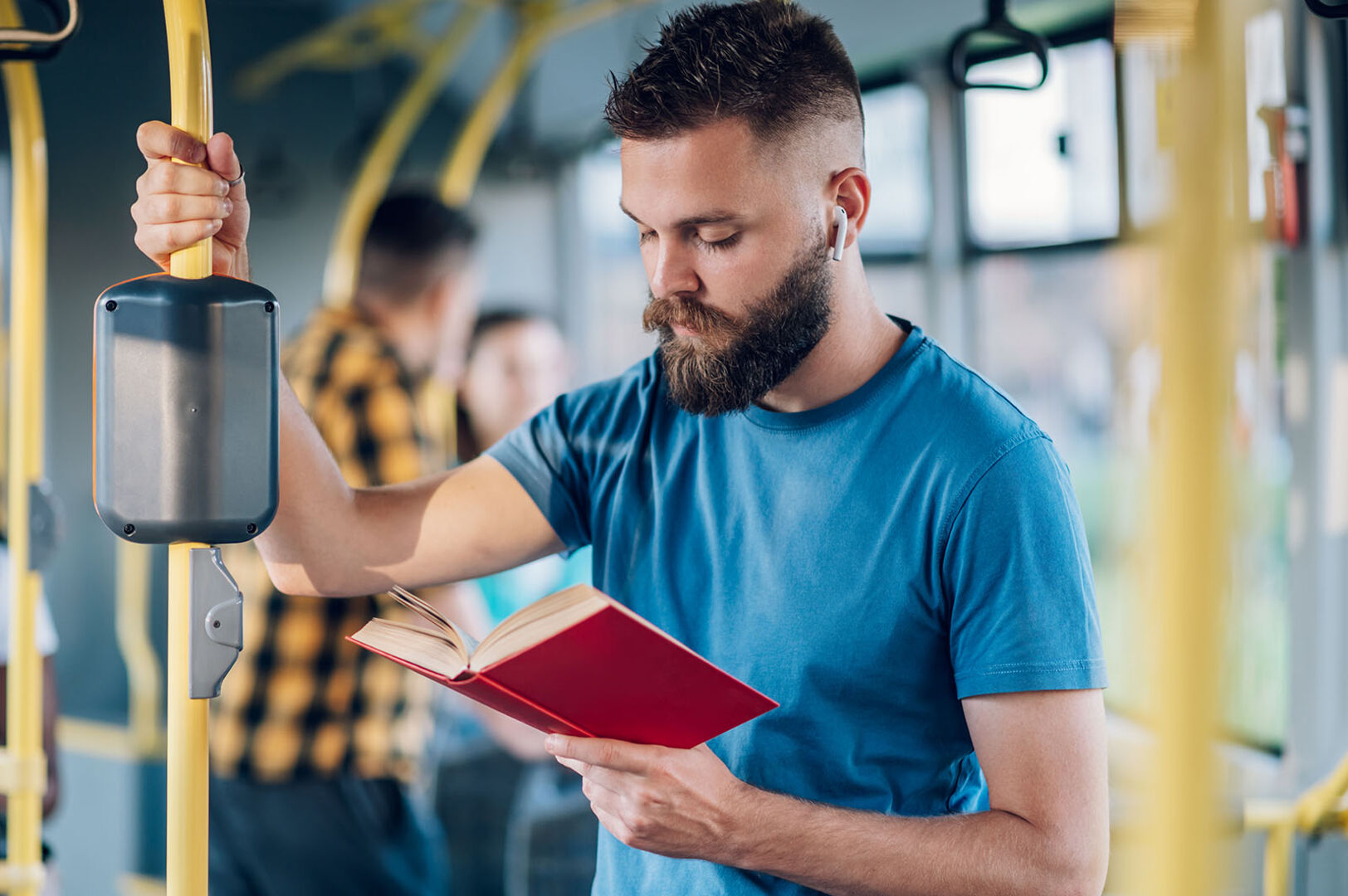 Mann liest im Bus | Credit: iStock.com/zamrznutitonovi