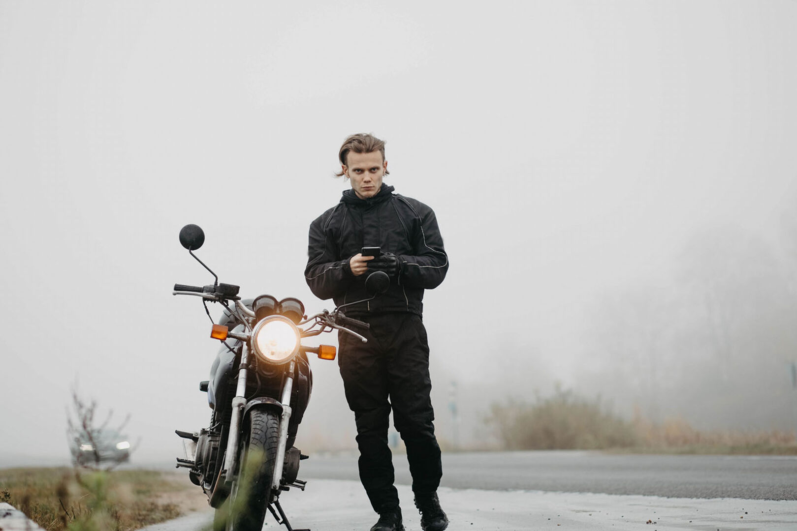 Biker steht im Regen | Credit: iStock.com/SaevichMikalai