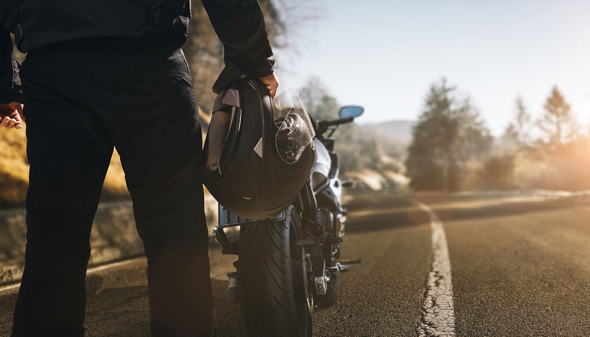 Biker steht vor Motorrad | Credit: iStock.com/Marcus Millo