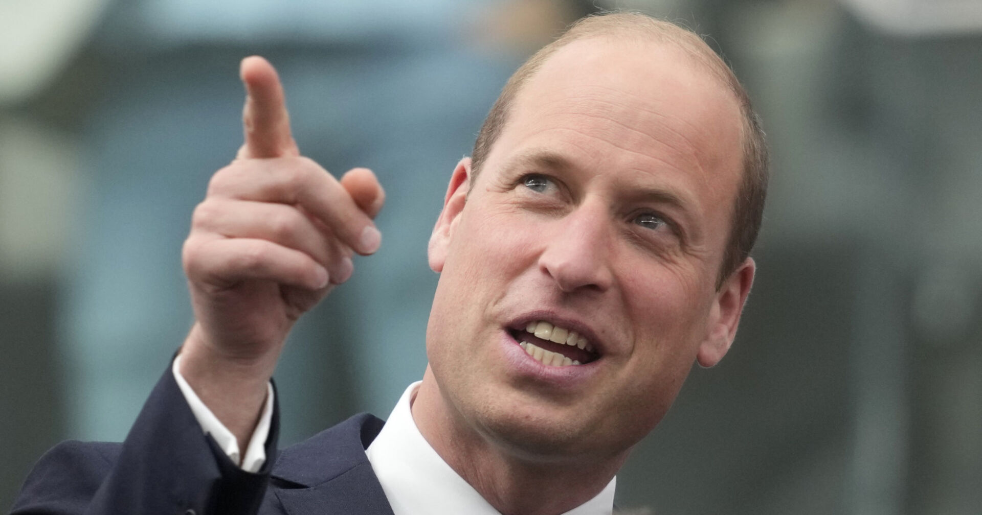 Ein Mann im Anzug zeigt mit dem Finger nach oben