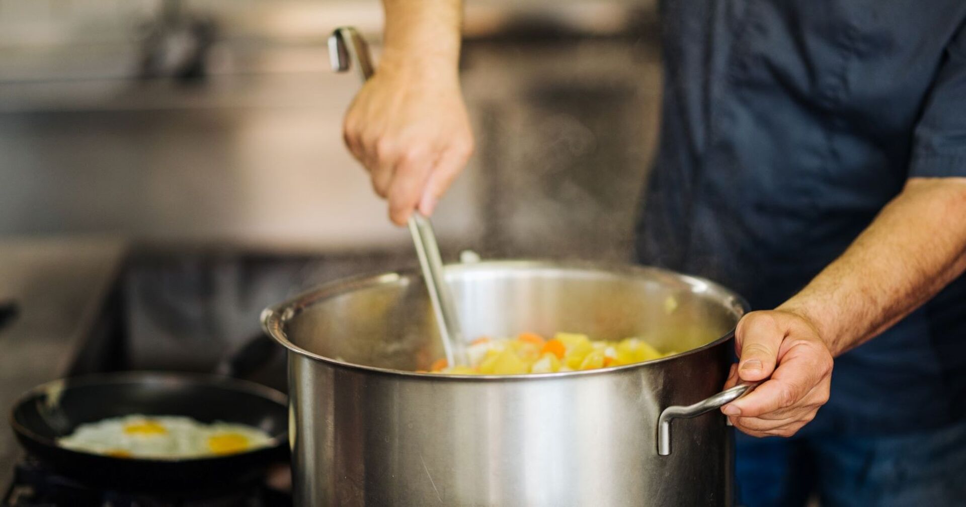Koch rührt in einem Kochtopf