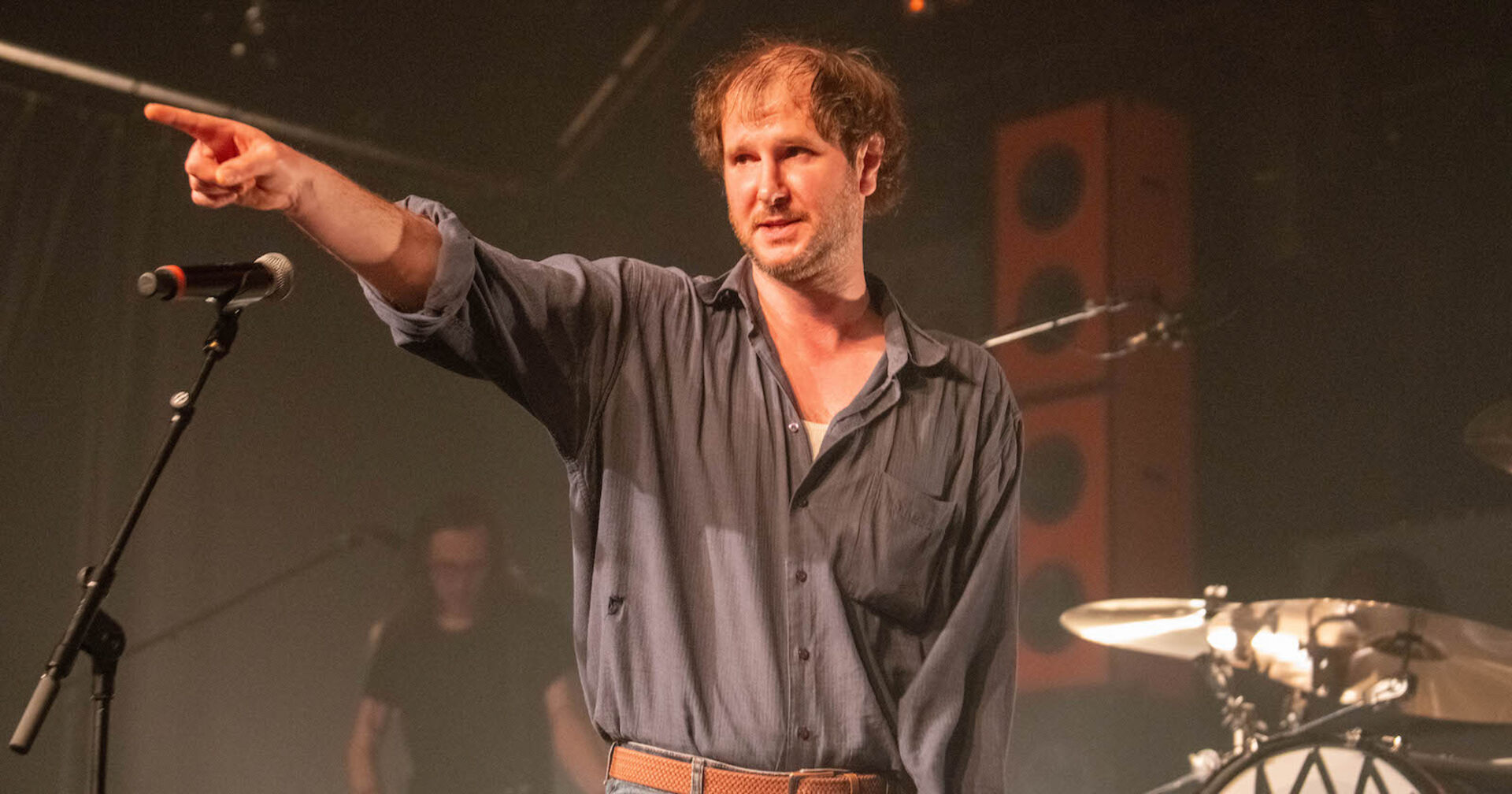 Marco Wanda in einem Hemd auf der Bühne. Er zeigt ins Publikum.