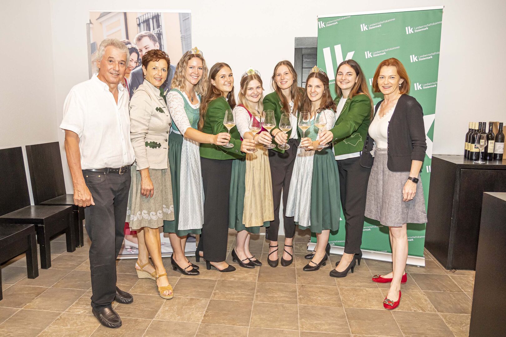Mehrere Frauen und ein Mann stoßen mit Wein an