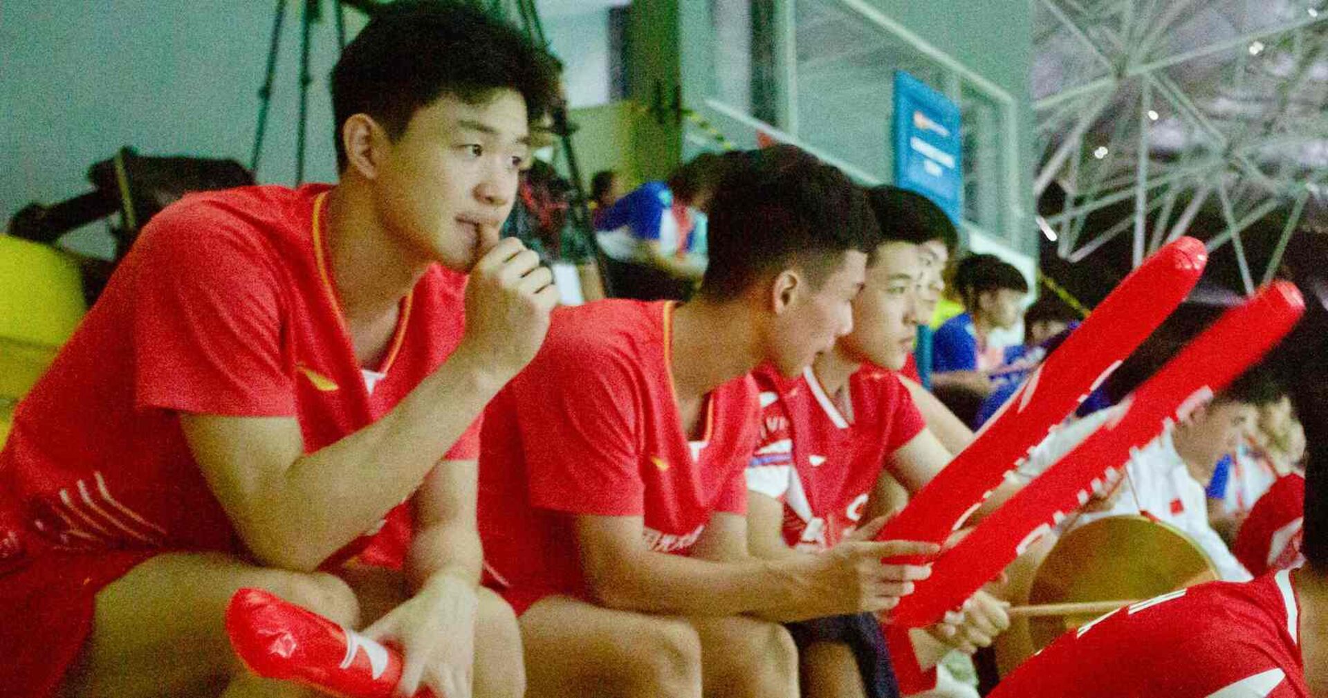 Chinesische Badmintonspielerinnen und -spieler beobachten und unterstützen ihre Mannschaftskameradinnen und -kameraden von der Tribüne aus bei den Junioren-Asienmeisterschaften 2024 in Yogyakarta.