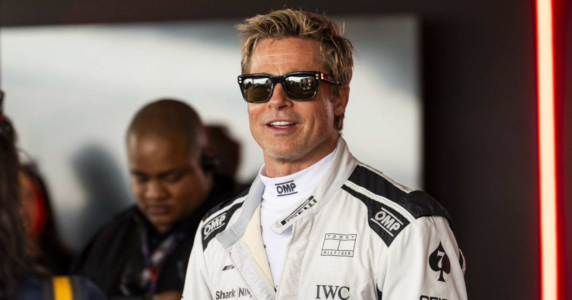 Ein Mann mit Sonnenbrille trägt einen weißen Rennanzug