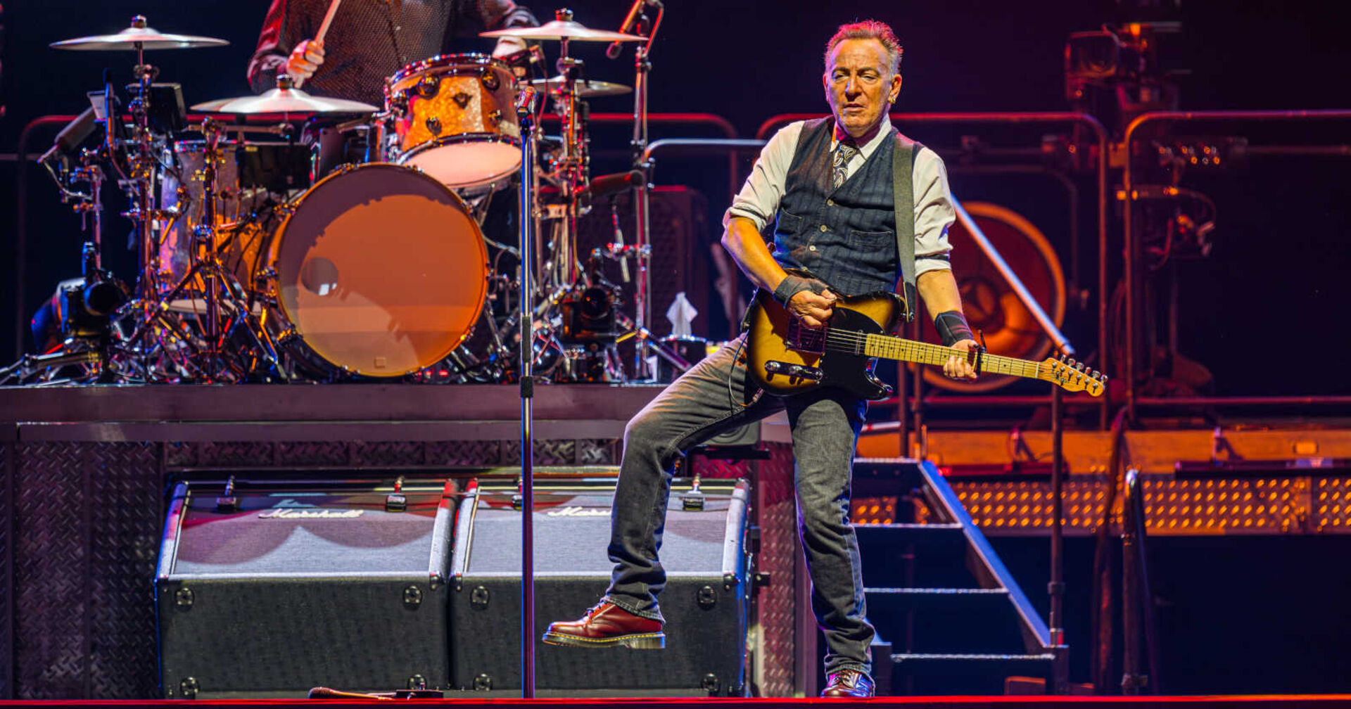 Ein älterer Mann spielt Gitarre auf einer Bühne