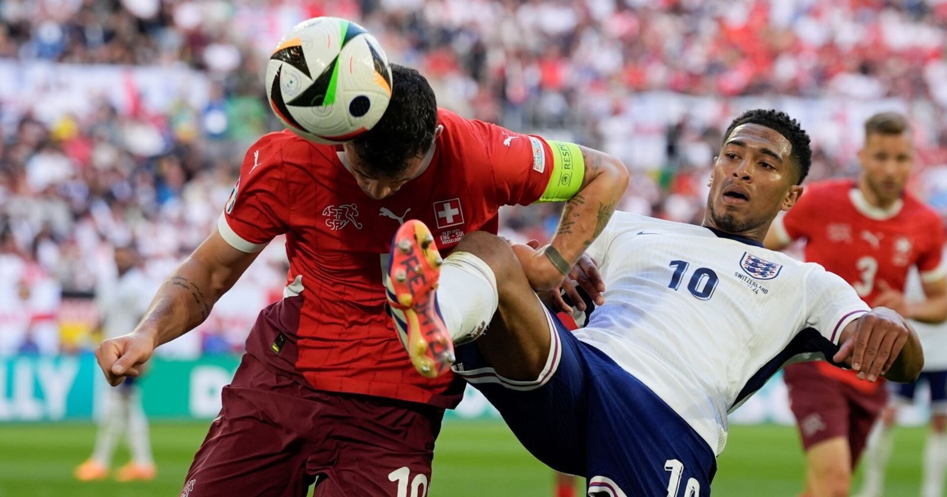 Englands Jude Bellingham (rechts) und der Schweizer Granit Xhaka kämpfen während eines Viertelfinalspiels zwischen England und der Schweiz bei der Fußball-Europameisterschaft 2024 in Düsseldorf um den Ball,