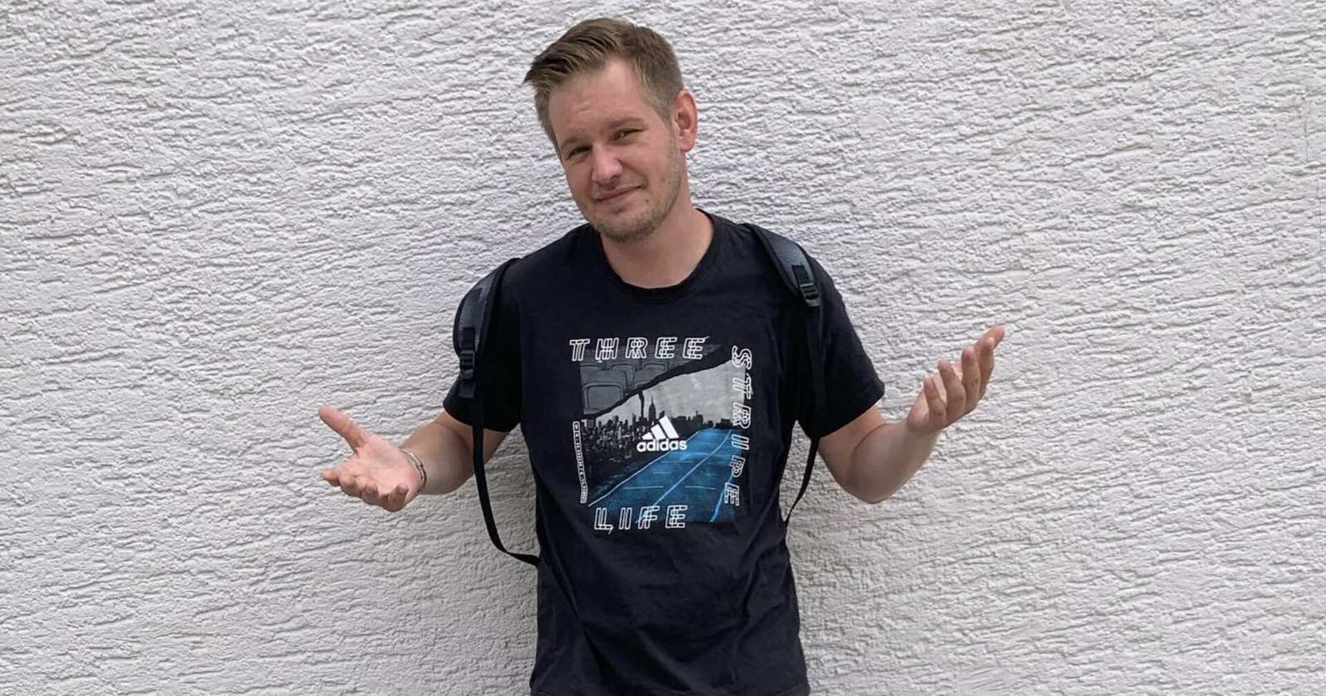 Falko Ochsenknecht steht vor einer Mauer.