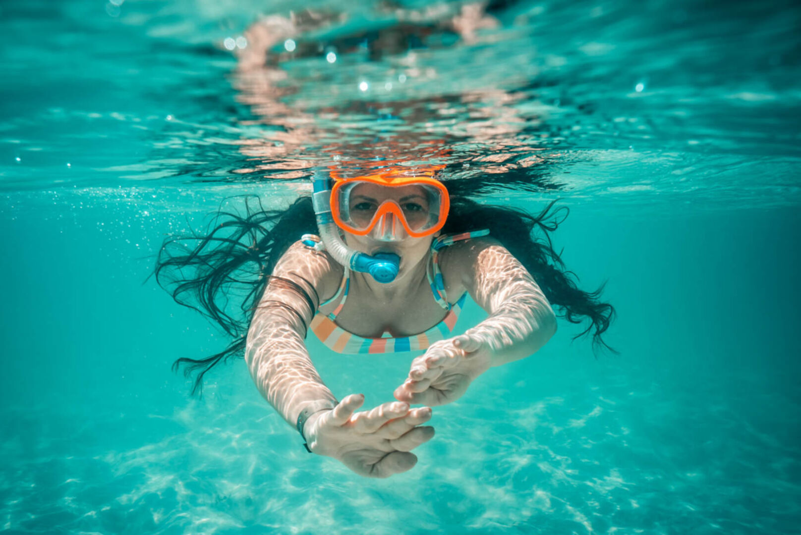 Eine Frau schnorchelt im blauen Meer