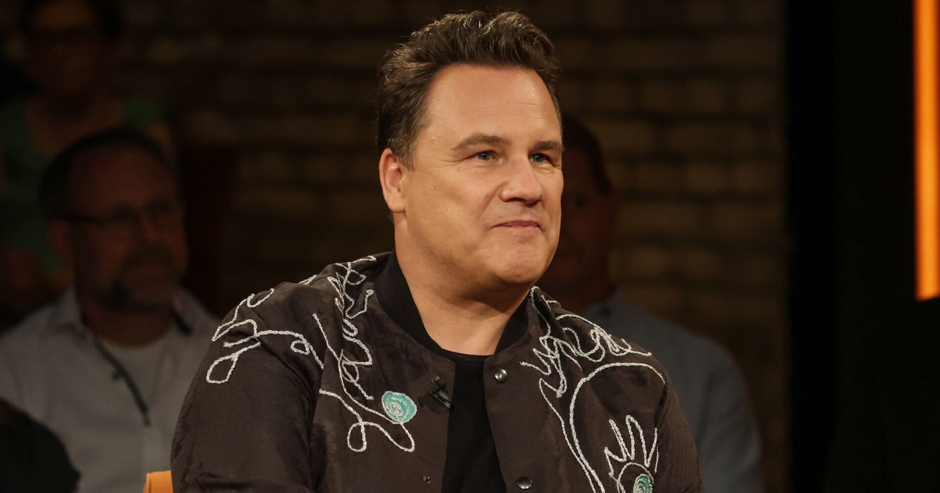 Guido Maria Kretschmer in einer bestickten Jacke bei einem Gespräch.