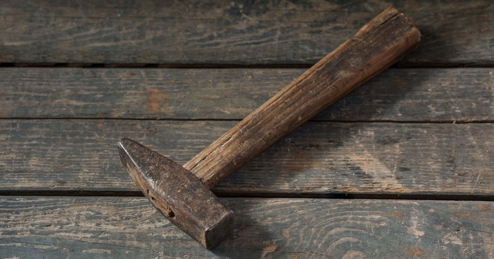 Eine alter Hammer liegt auf einem Tisch.