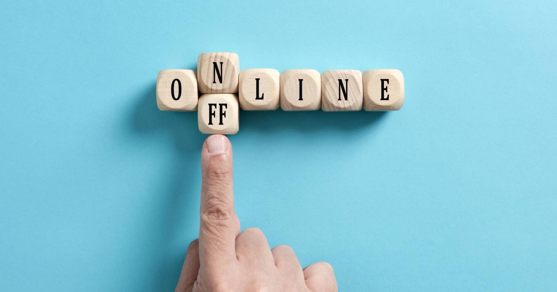 Finger der den Buchstaben N vom Wort Online wegschiebt mit einem Doppel-F Stein, damit das Wort offline ergibt