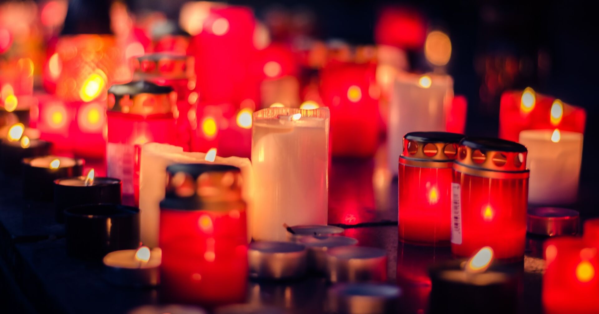 Viele rote und weiße Grabkerzen.