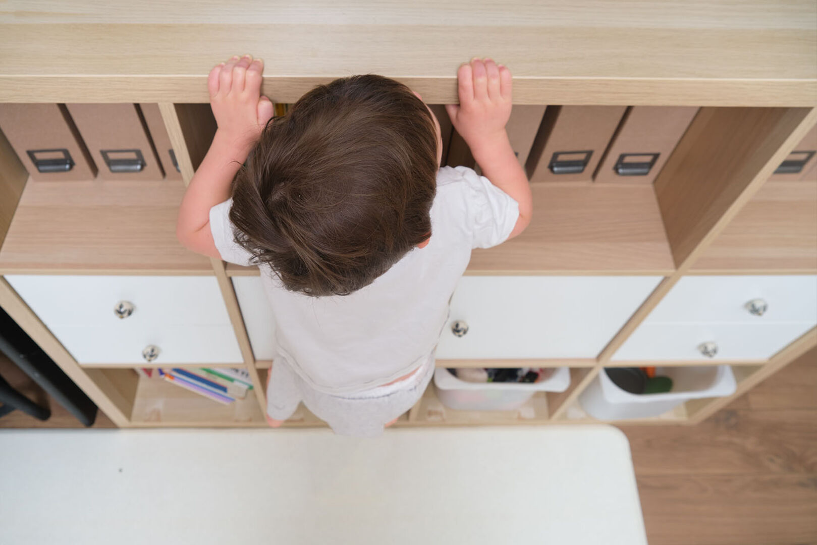 Kind klettert auf Regal | Credit: iStock.com/Andrey Zhuravlev