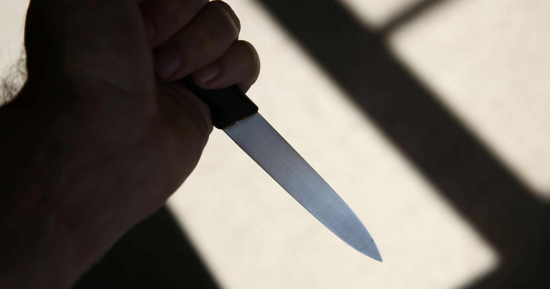 Ein Mann hält ein Messer in der Hand.