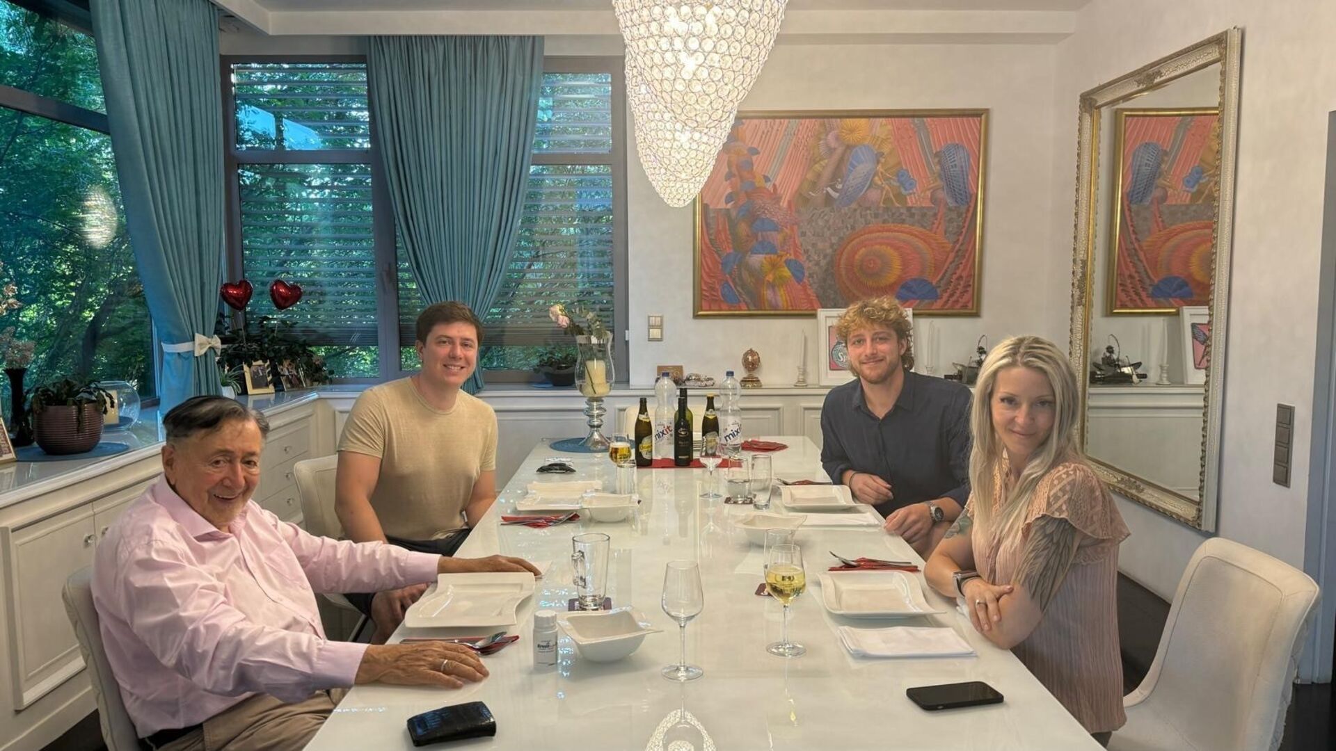 Richard Lugner mit seinen Enkelkindern und Ehefrau Simone am Tisch.