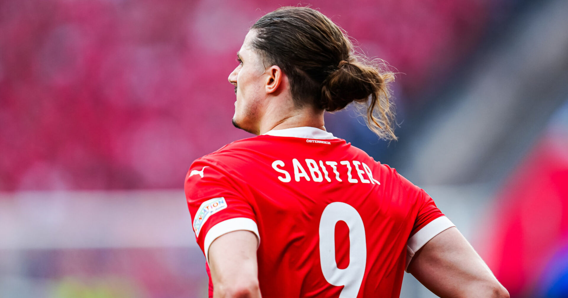 Ein Fußballspieler steht mit dem Rücken zur Kamera am Feld