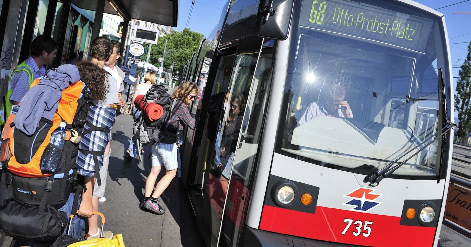 Rucksacktouristen steigen in Wien in eine Straßenbahn ein