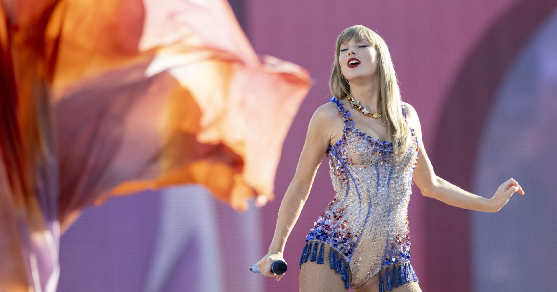 Blonde Sängerin steht in einem Glitzerbody auf der Bühne