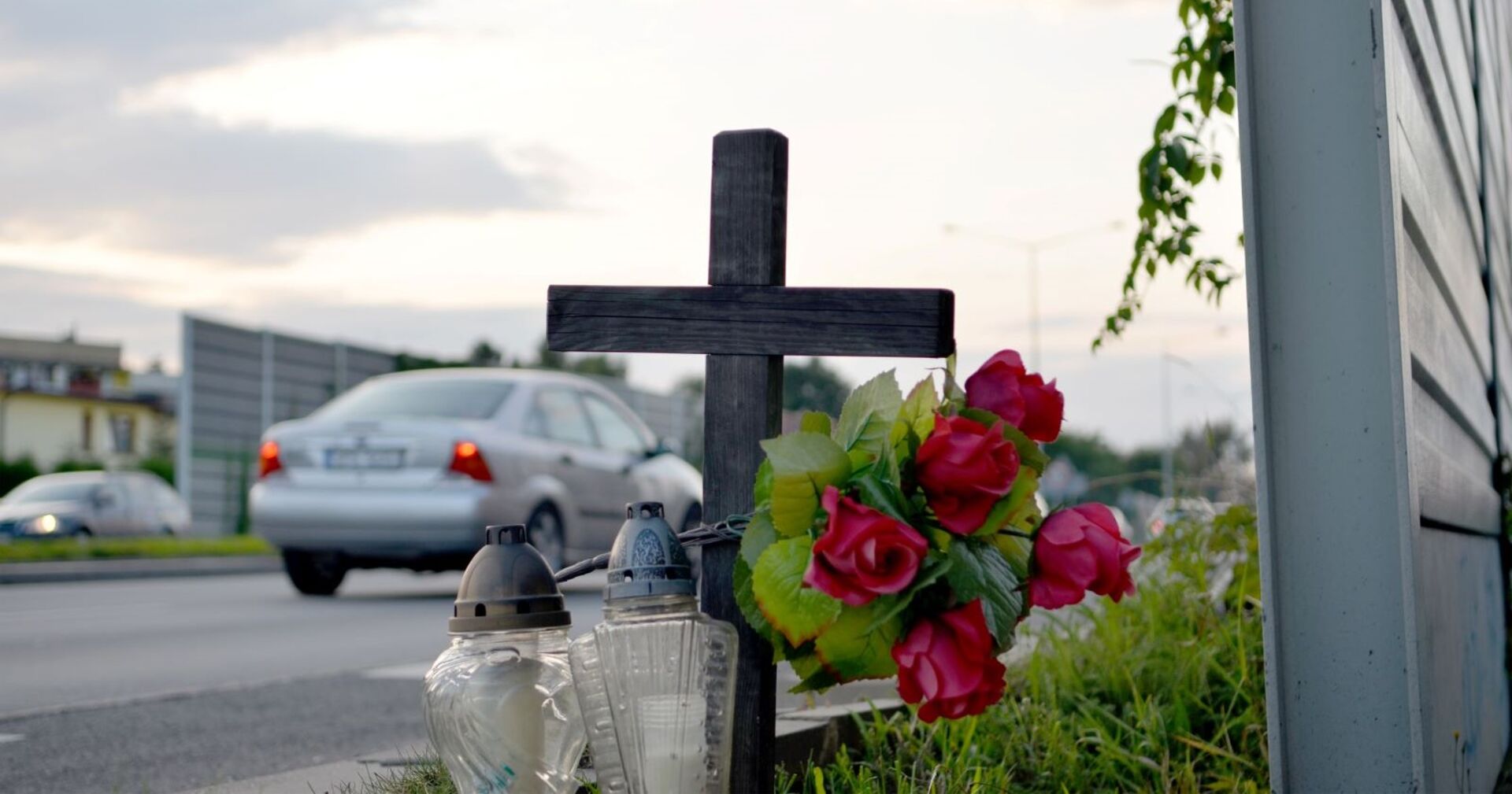 Ein Kreuz und Kerzen am Fahrbahnrand.