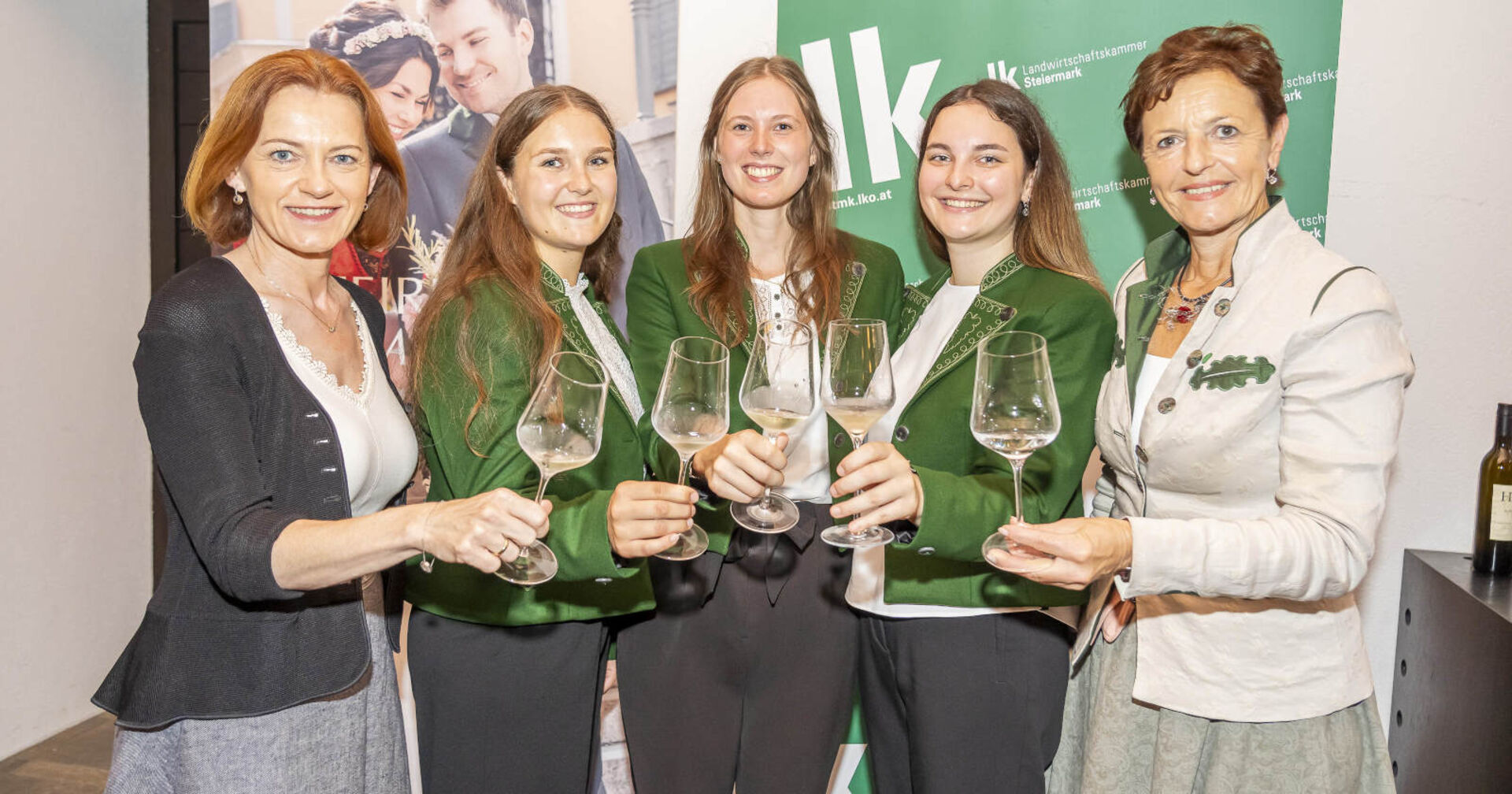 Fünf Frauen stoßen mit Wein an