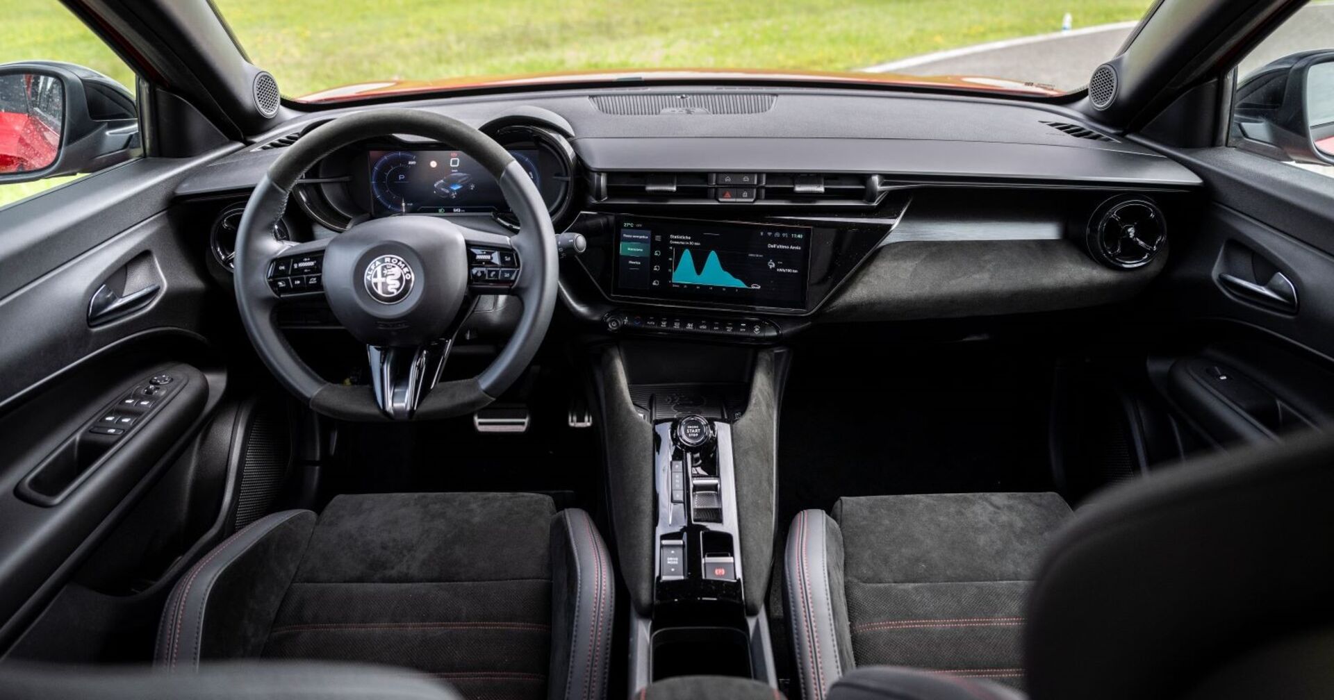 Das Innere des Alfa Romeo Junior: Die Sitze und auch das Lenkrad sind schwarz und machen einen eleganten Eindruck. Das kleine Navigationsgerät ist eingeschaltet und zeigt eine Grafik.