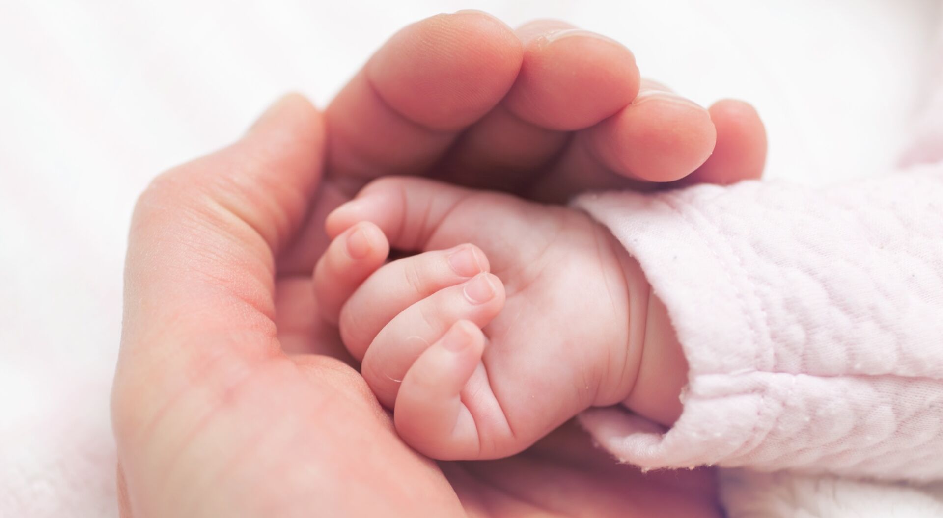 Babyhand in Hand der Mutter