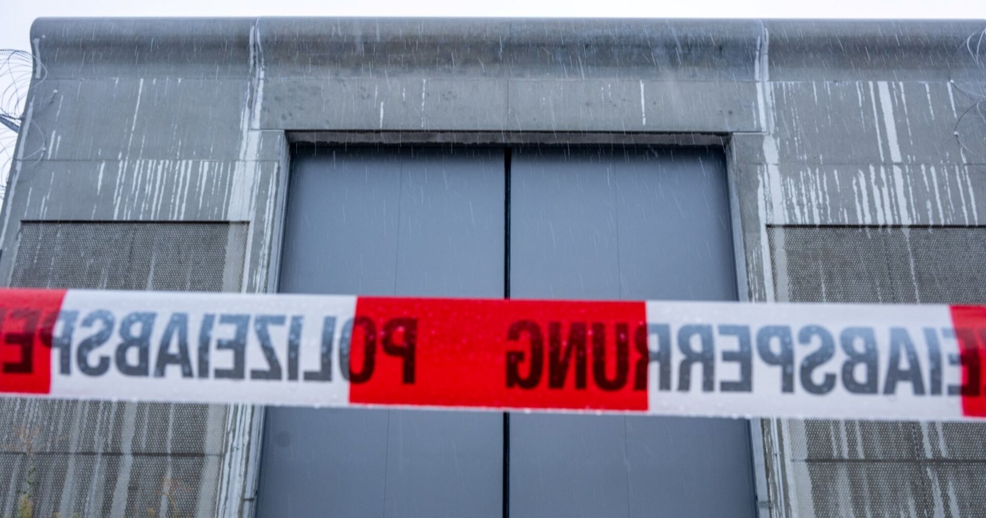 Tor des Krankenhauses, davor befindet sich ein Polizeiabsperrband