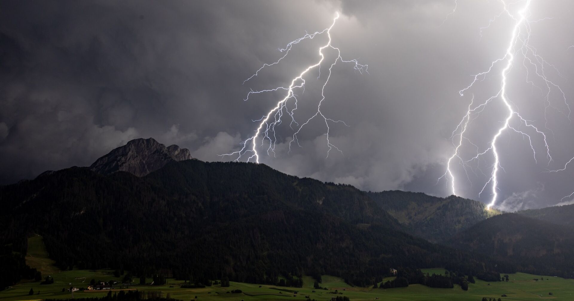 Gewitter über einem Wald in den Bergen.
